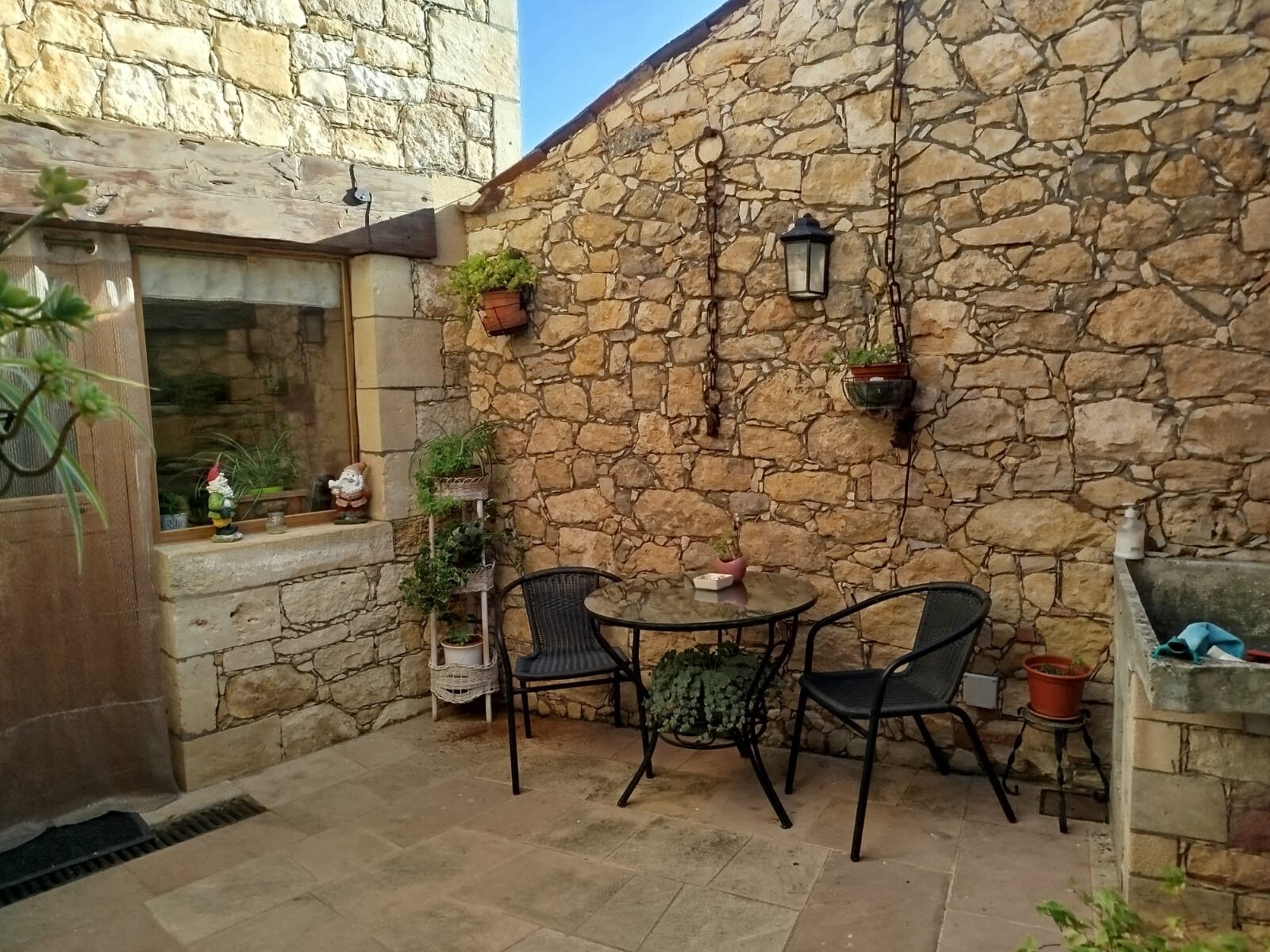 Patio de piedra con mesa y sillas — Mi Rinconcillo