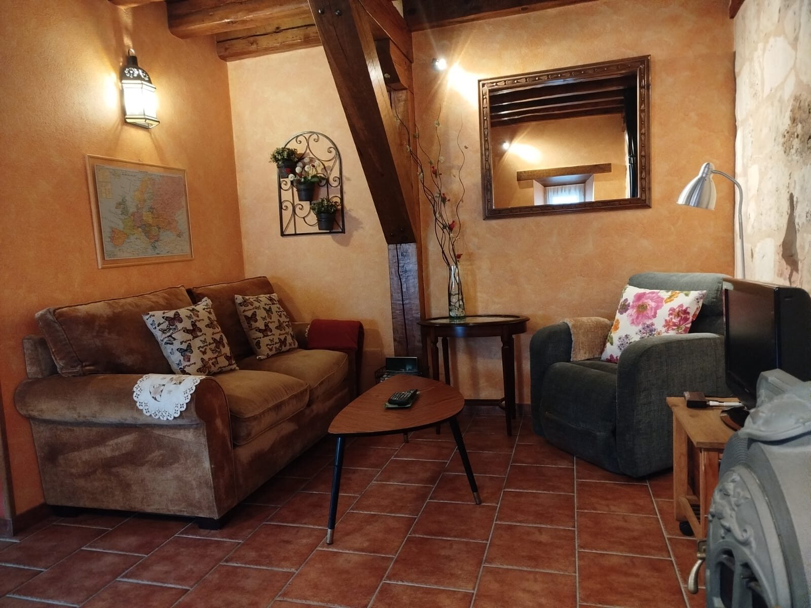 Salón con sofá, sillón y estufa de leña